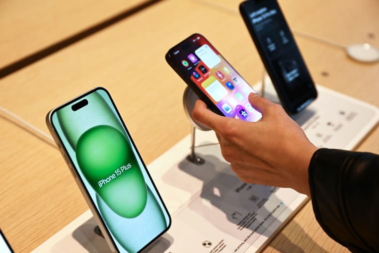 A person holds an iphone on a display table