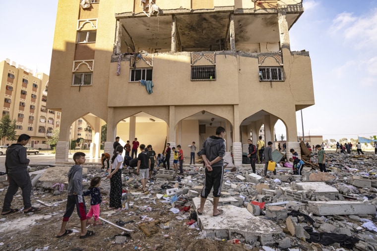 People examine the remains of a building destroyed in an airstrike