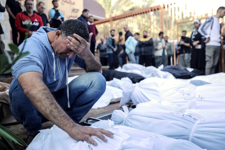 A man cries over bodies of those killed in Israeli airstrikes