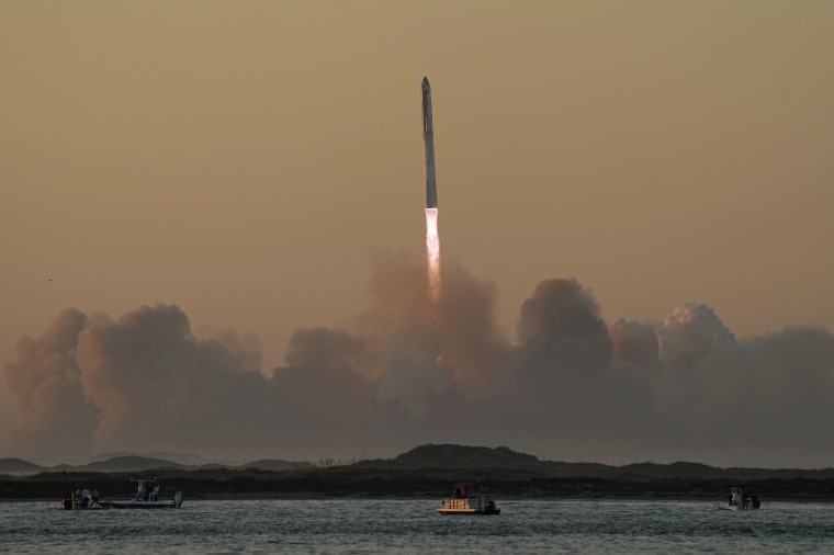 A rocket is seen ascending into the sky near a body of water