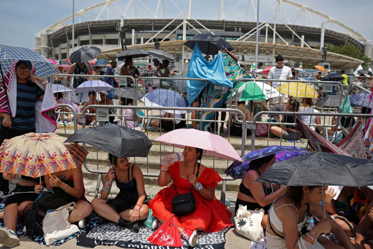 Image: People holding umbrellas waiting for Taylor Swift's concert in Rio de Janeiro