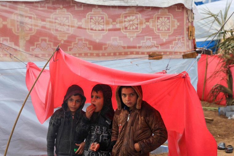 Displaced Palestinian children, who fled the northern Gaza Strip, stand under a makeshift shelter on the grounds of the Nasser Hospital where they are sheltering in Khan Younis, southern Gaza, on Nov, 20, 2023.