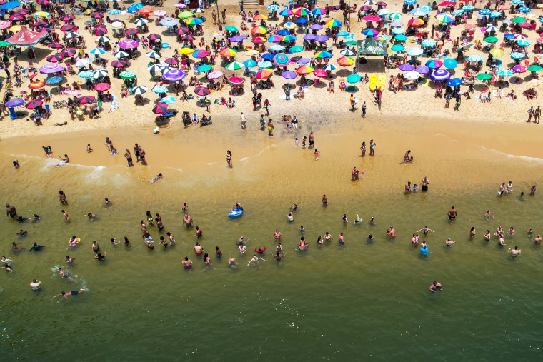 Dangerous Heat Wave Hits Rio De Janeiro aerial beach swimmers umbrellas colorful