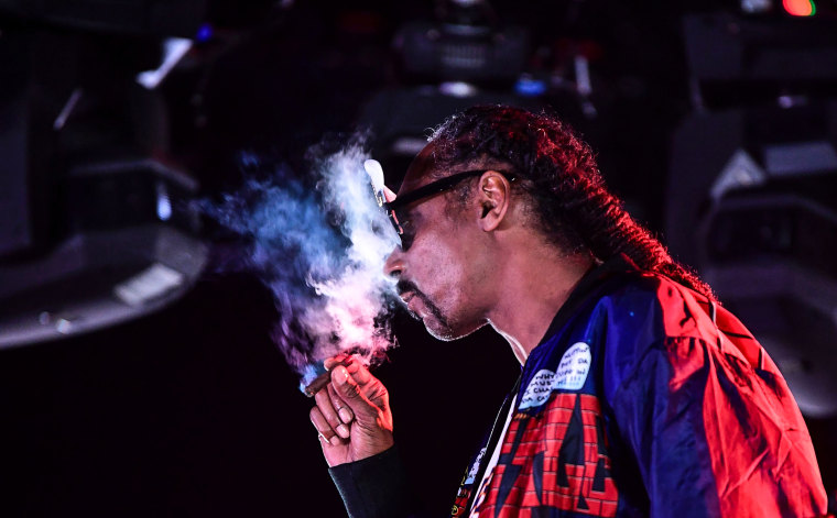 Snoop Dogg smokes while performing on stage during a performance in Ventura, Calif., 