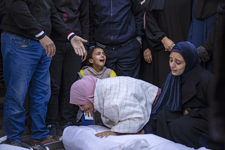 Palestinians mourn their relatives at the hospital in Khan Younis, Tuesday, Nov. 21, 2023.