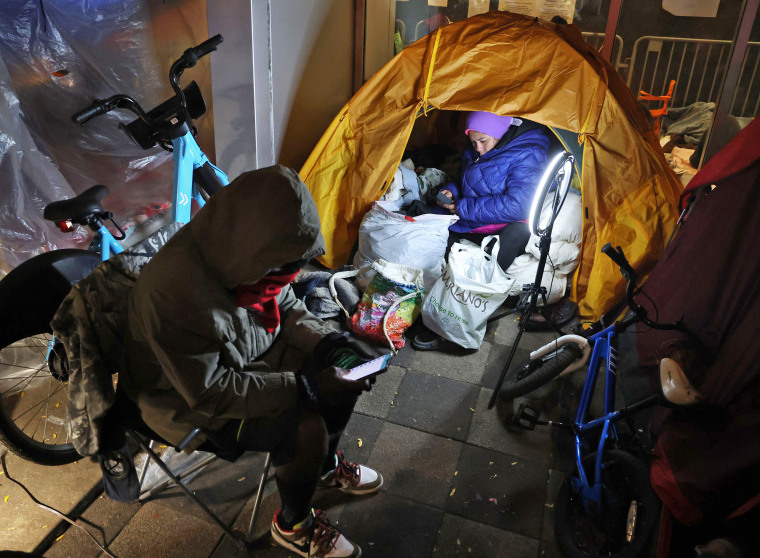 Yessica Karolina Badell Palmar, right, a migrant from Venezuela, in her tent outside the Chicago police 1st District station on Oct. 30, 2023. 
