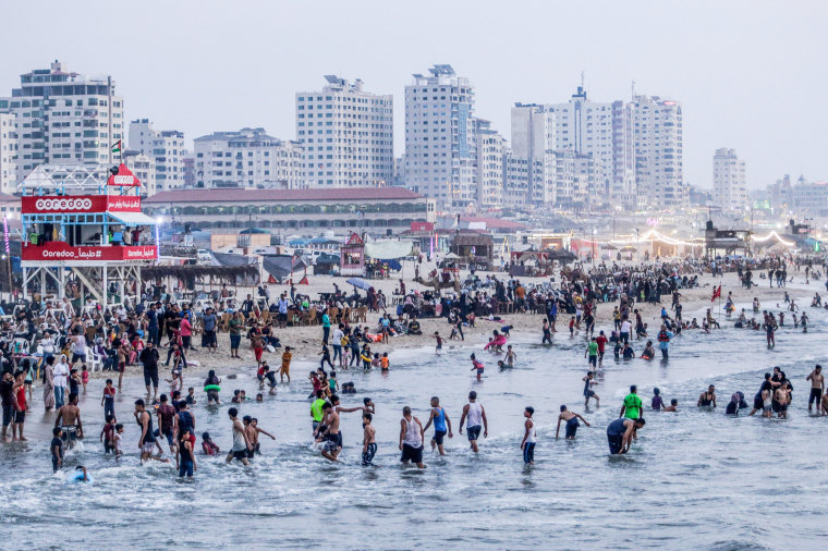 Palestinians spend time at the beach of Gaza during a hot