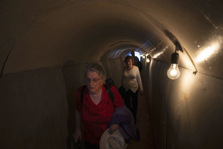 People walk through an installation in Tel Aviv on simulating a tunnel in Gaza in an act of solidarity with hostages believed to be held underground by Hamas.