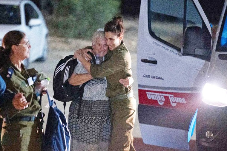 An Israeli soldier embraces former Hamas hostage as she exists a van