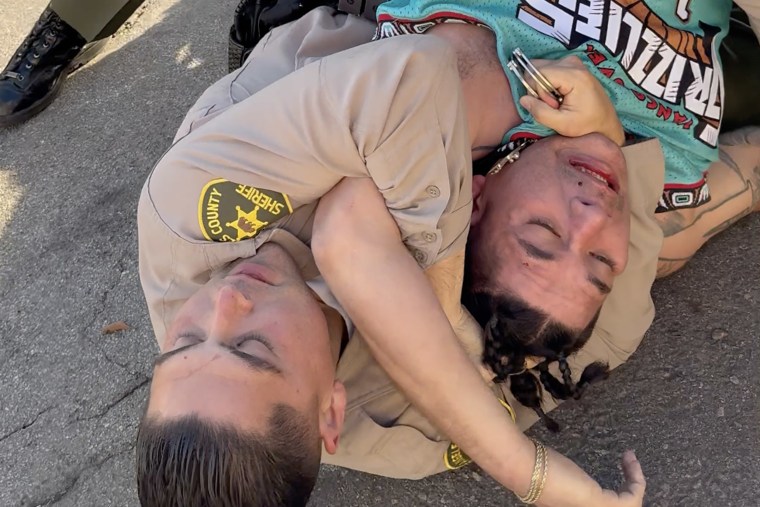 An officer holds amputee on the ground during an arrest.