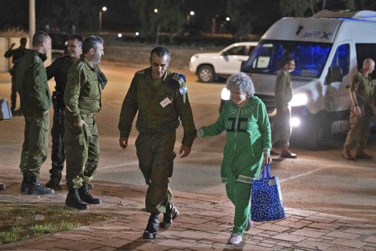 Ruth Munder kävelee israelilaisen sotilaan kanssa pian Israeliin saapumisensa jälkeen 24.11.2023.  