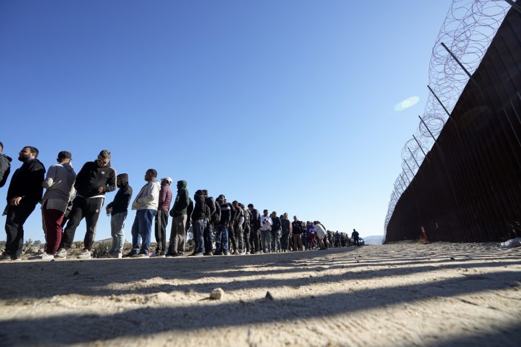 Migrantes esperan en fila para recibir alimentos después de cruzar la frontera de Estados Unidos con México, el 24 de octubre de 2023. 