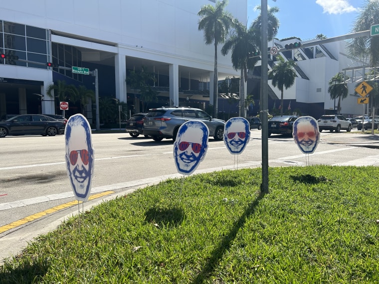 Joe Biden's campaign placed "Dark Brandon" signs outside the site of the GOP presidential debate in Miami today.