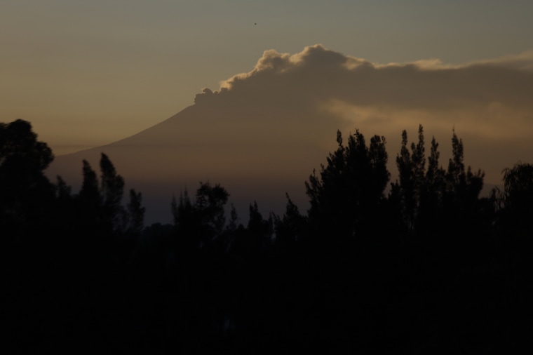Vista del Volcán Popocatépetl desde la Ciudad de México emitiendo humo al amanecer.