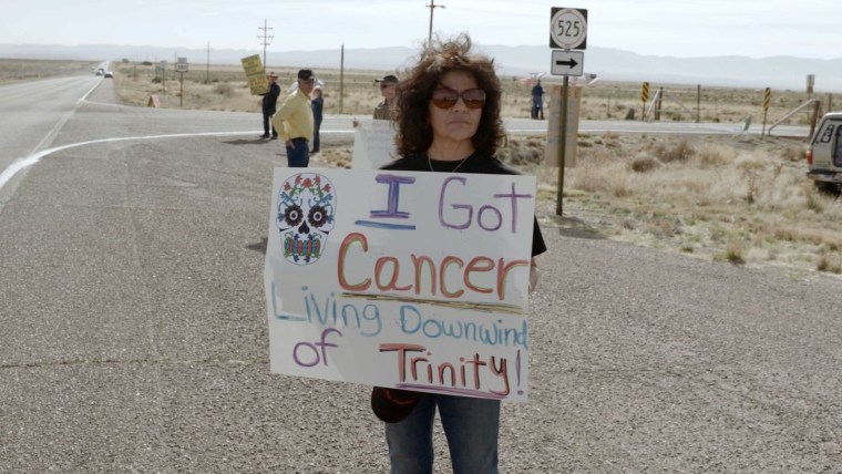 Tina Cordova, descendiente de personas que estuvieron expuestas a partículas de la prueba nuclear Trinity, durante una protesta. Está sosteniendo un cartel que dice "Me dio cáncer al vivir cerca del sitio Trinity"