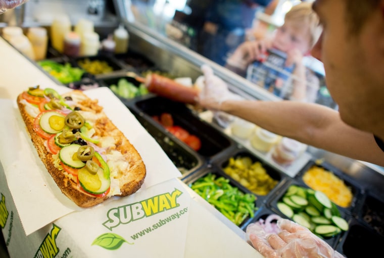 A worker makes a sandwich inside the fast food chain Subway in Hannover, Germany, 21 August 2015. 