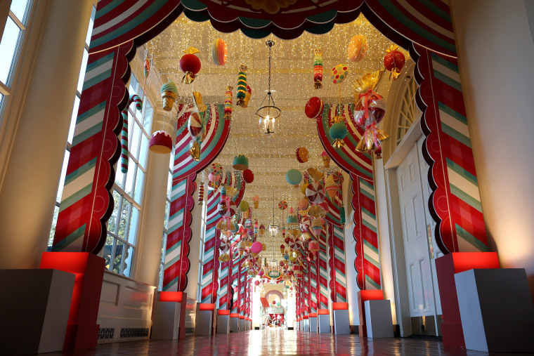 Candy-themed ornaments hang from the ceiling of the hallway between the East Wing and the Residence at the White House.