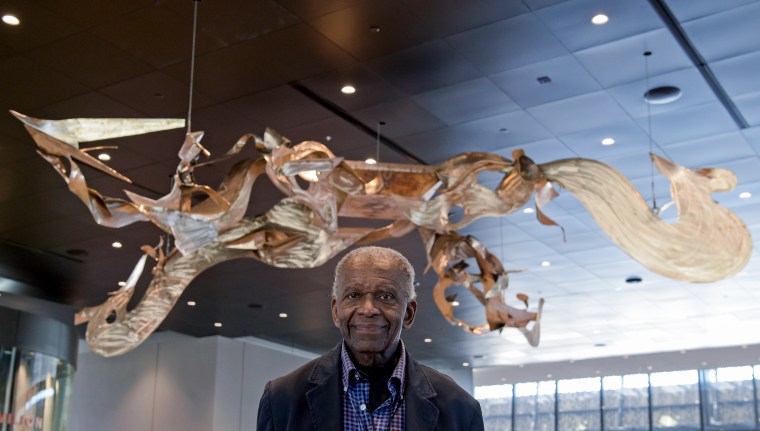 Richard Hunt, an African-American abstract sculptor and artist, stands with his sculpture on display at the National Museum of African American History and Culture in Washington, DC. on Sept. 14, 2016.