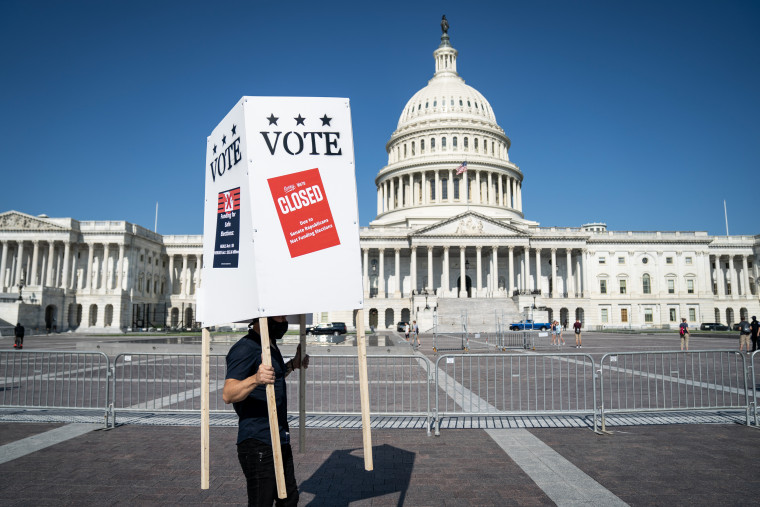A demonstrator walks with a mock voting booth outside of the Capitol to draw attention to the U.S. Senates failure to allocate funding for safe elections in its current coronavirus relief bill in Washington, D.C. on Aug. 5, 2020. 