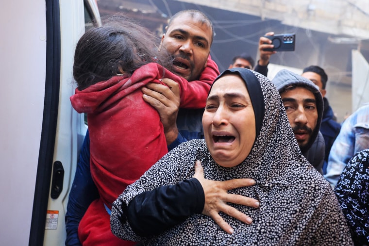 A Palestinian woman cries as injured are being transported in an ambulance following Israeli airstrikes in the refugee camp in Rafah, southern Gaza Strip, on Dec. 1, 2023, as fighting broke out shortly after the expiration of a seven-day truce between Israel and Hamas. 