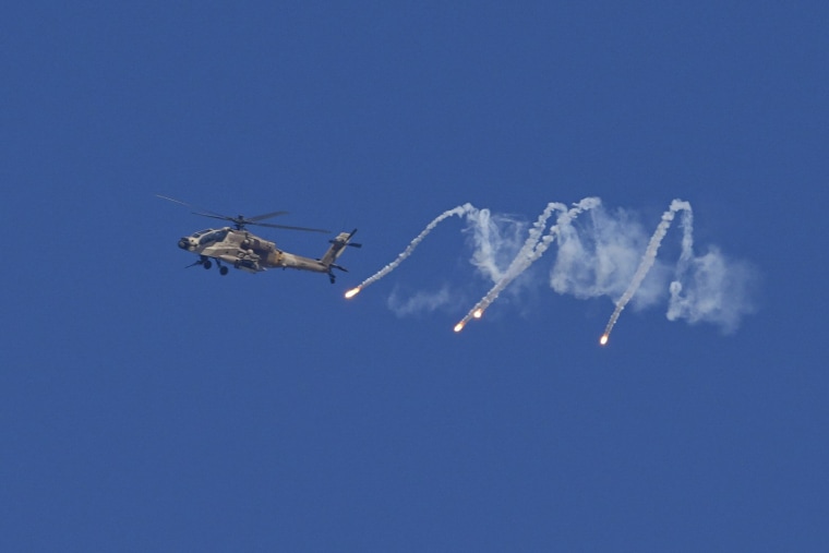 An Israeli military helicopter releases flares over the Israel-Gaza border as seen from southern Israel, Monday, Dec. 4, 2023. 