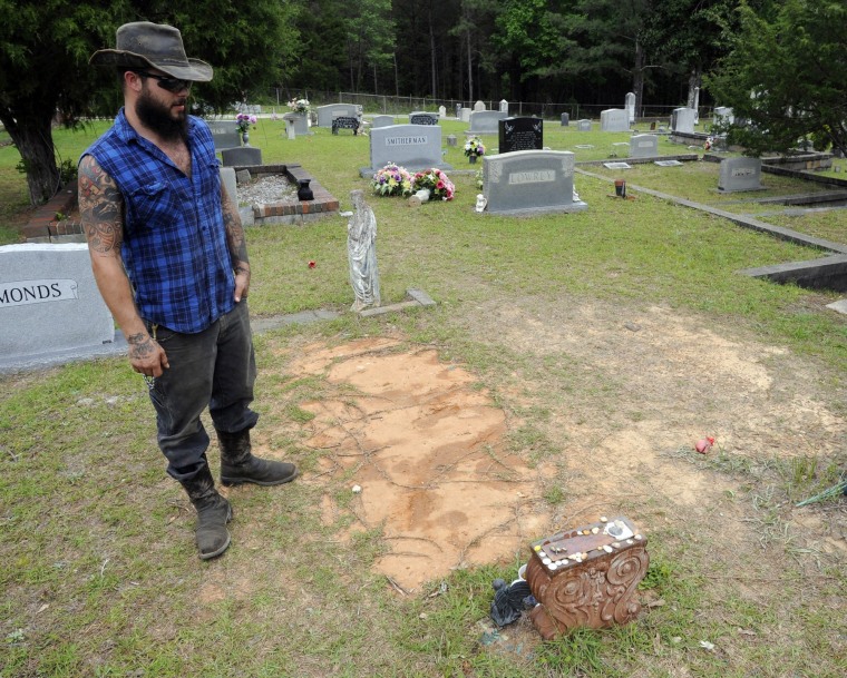 Tyler Goodson of the hit podcast "S-Town" stands at the grave in Green Pond, Ala., of his late friend John B. McLemore, who is also featured in the show, on May 3, 2017. 