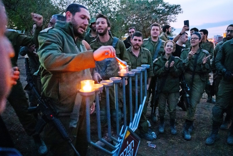 Israeli soldiers light candles on the first night of Hanukkah near the Gaza border on Dec. 7, 2023 in southern Israel. 