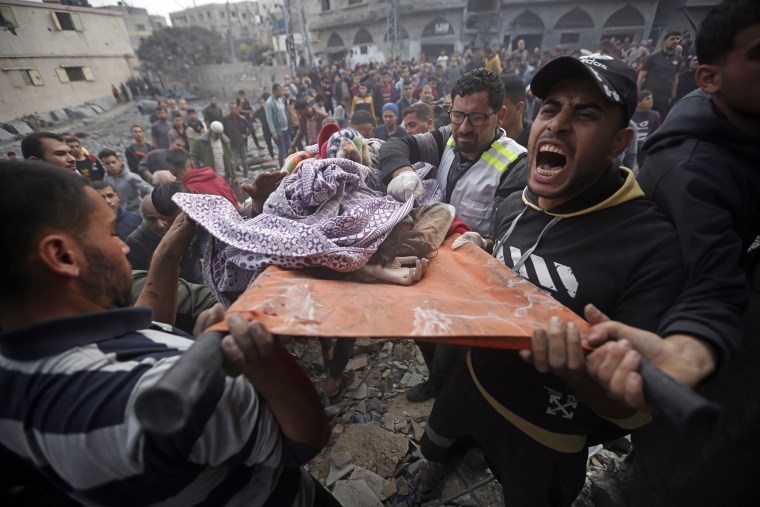 Palestinians carry a dead girl found under the rubble of a destroyed building in Khan Younis, southern Gaza, Thursday, Dec. 7, 2023.