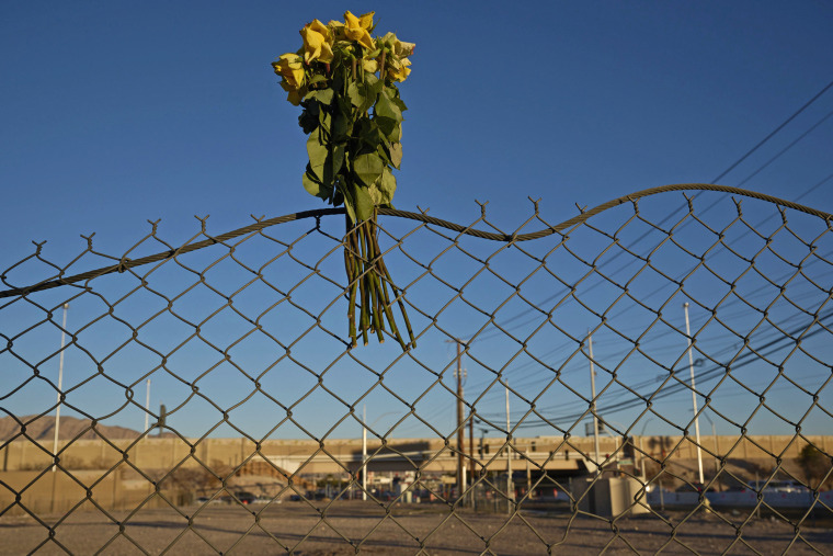 Flowers hang on a fence near the site of a shooting at a homeless encampment in Las Vegas.