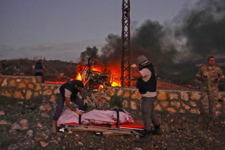 Civil Defense workers remove the body of Reuters videographer Issam Abdallah who was killed by Israeli shelling in south Lebanon  on the border with Israel on Oct. 13, 2023. .