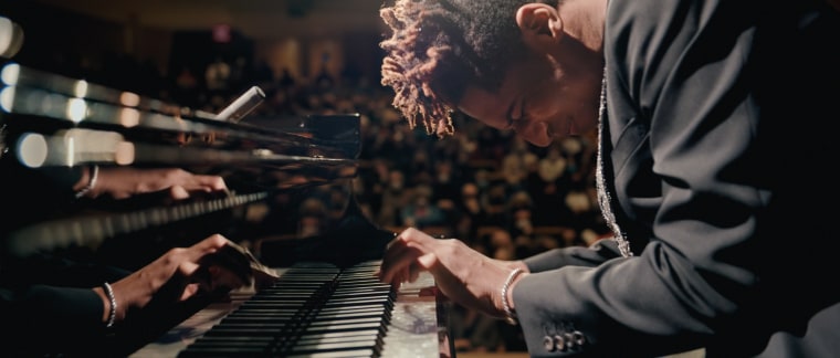 Jon Batiste on the piano during a concert in "American Symphony."