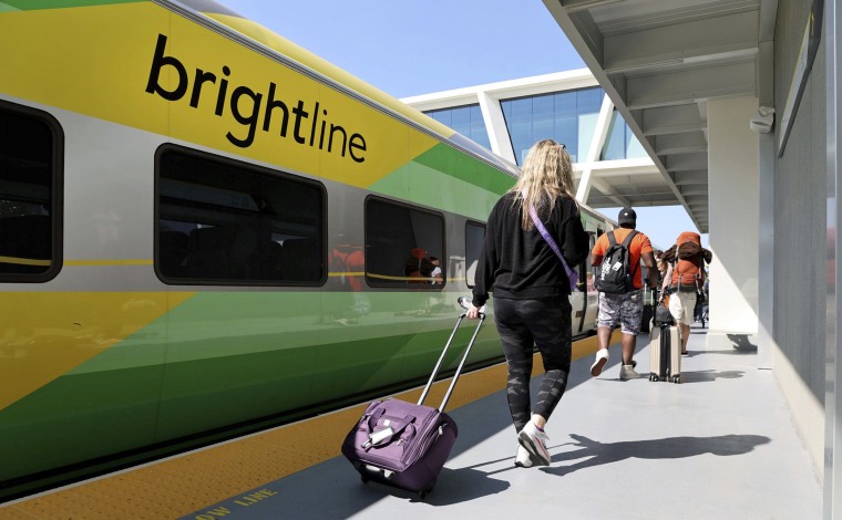 Passengers board a Brightline train to West Palm Beach, Fla., at the Fort Lauderdale station on Feb. 27, 2023.