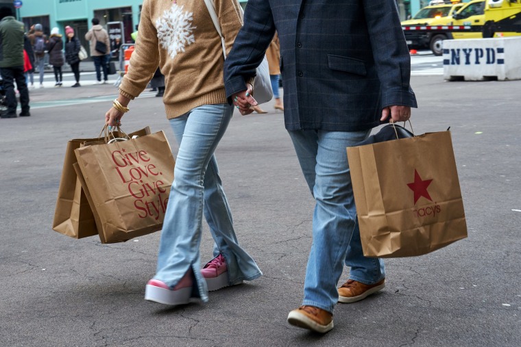 Shoppers carry Macy's bags outside the flagship store on Black Friday in New York