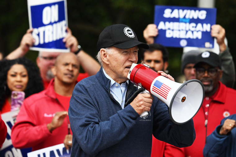 President Joe Biden speaks into a megaphone on a UAW picket line