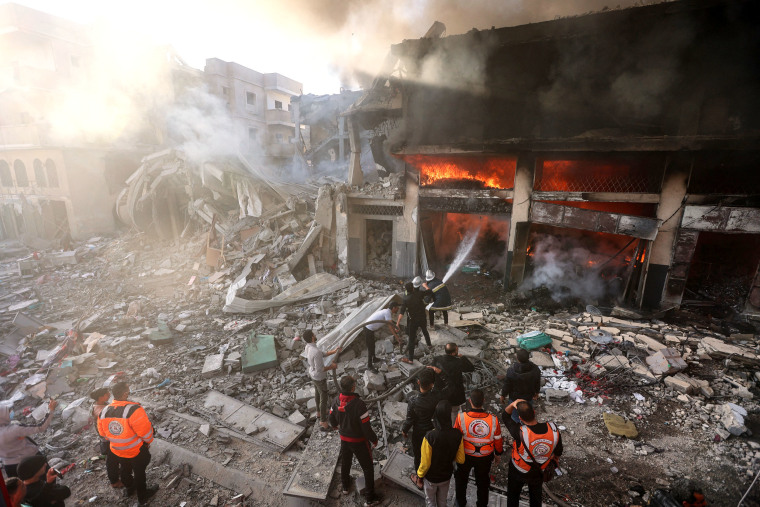 Firefights battle flames in a building hit by an Israeli strike in Khan Yunis
