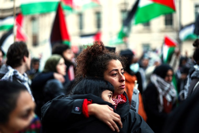 Two people hug during a moment of silence during a protest.