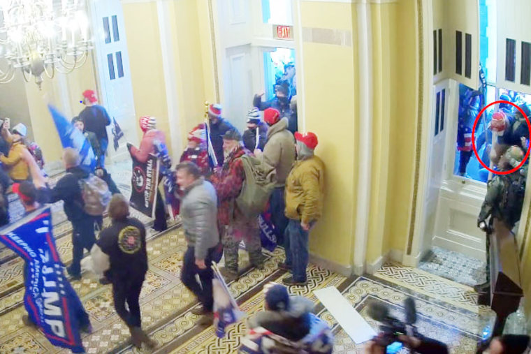 Paul Caloia, far right and circled in red, enters the Capitol though a window