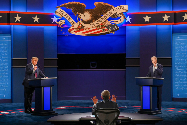 Donald Trump and Joe Biden exchange arguments as moderator and Fox News anchor Chris Wallace raises his hands to stop them.