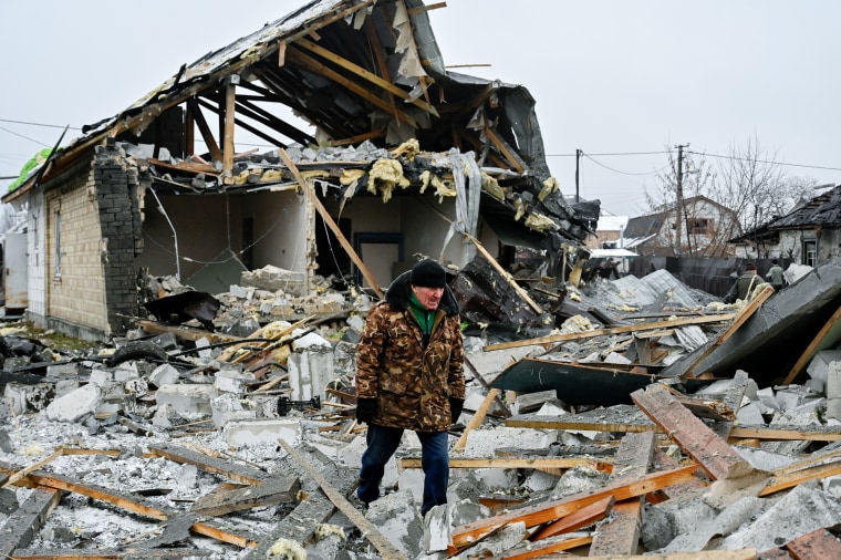 A man inspects a destroyed house that was damaged as a