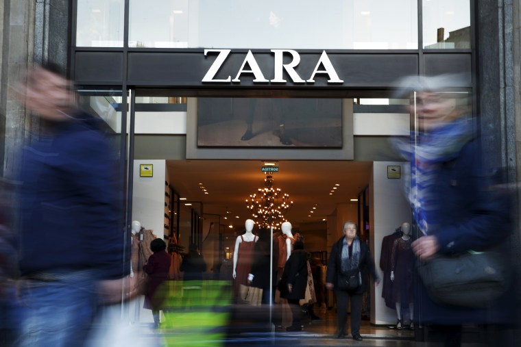 Image: People walk past a Zara store in Barcelona