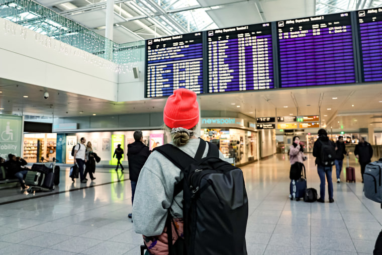 A person looks at a flight call board at the Munich International Airport