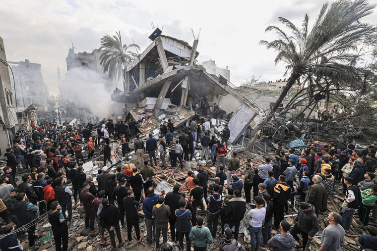 Palestinians gather around the destroyed Shehada family home following the Israeli bombardment of Rafah in the southern Gaza Strip on Dec. 14, 2023.