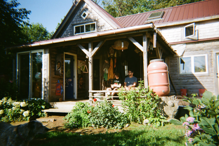 Peter Kalmus sits with his son Zane on a porch swing at the Possibility Alliance. 