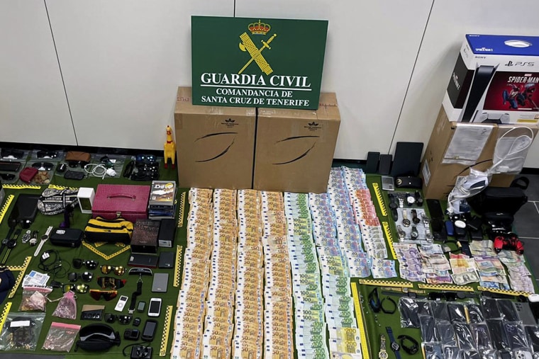 In this photo provided by the Guardia Civil on Friday, items stolen from suitcases are displayed on the Canary island of Tenerife, Spain. 