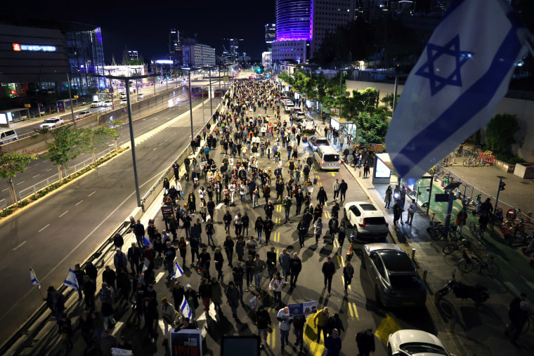 People March along a Tel Aviv boulevard in protest