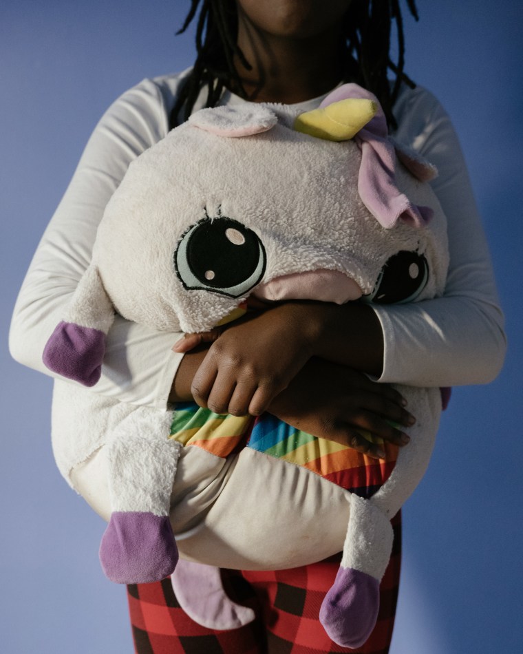 Benton's daughter holds one of her stuffed animals in her bedroom on Dec. 16, 2023.