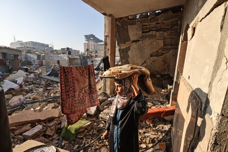 A woman carries bread in her destroyed house in Rafah in the southern Gaza Strip on Dec. 18, 2023.
