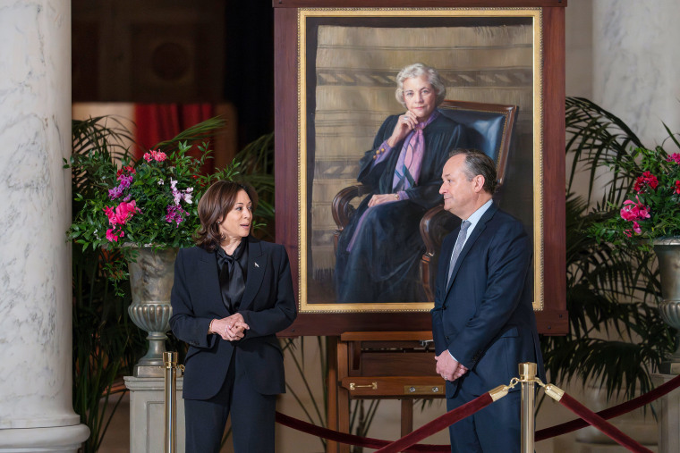 Kamala Harris and Doug Emhoff  walk past a portrait of Sandra Day O'Connor.