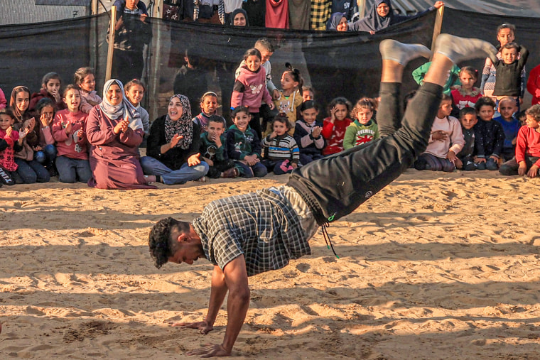 A man performs for children in Rafah, southern Gaza, on 
De. 18, 2023.