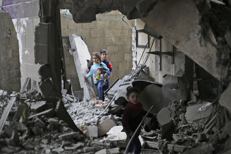 Palestinian children walk through the rubble after an Israeli strike on residential buildings in Rafah, southern Gaza, on Dec. 14, 2023. 